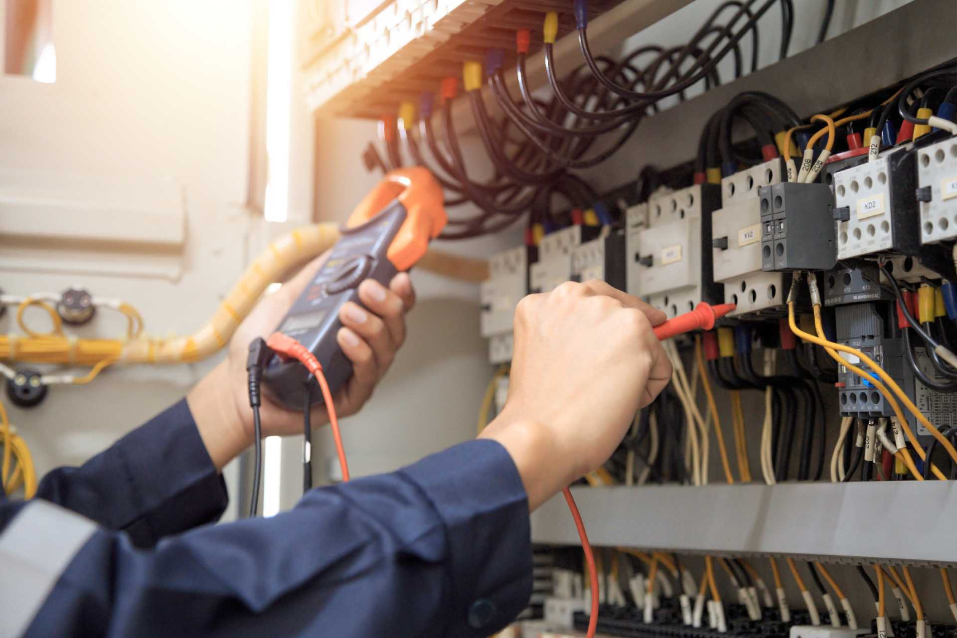 An electrician working on a panel